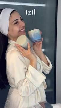 Créatrice souriante tenant des masques corporels Izil mettant en avant la notoriété via la publicité Snapchat.