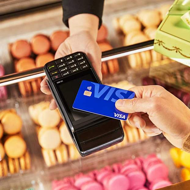 Paiement sans contact avec carte Visa dans une boulangerie soutenant les commerces locaux en France.