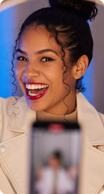 An influencer records a video with her phone.