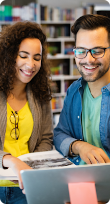 Two marketers look at a campaign on a laptop.